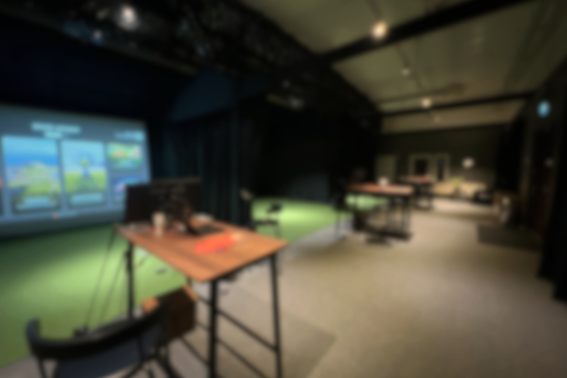 Inomhusgolf-bås hos ACE Indoor Golf med TrackMan-skärm och varmt belysning